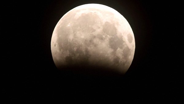 What is the difference between a total and partial lunar eclipse