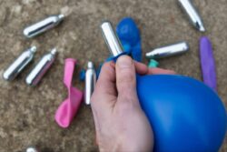Police Catch Man Inhaling Laughing Gas from Balloon. Find 48,000 Cans in His Residence